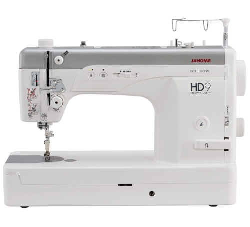 Maszyna do szycia Janome HD9 Heavy Duty, w kolorze białym, z metalowym stelażem. Widoczna igła, pokrętła do regulacji oraz przyciski funkcyjne. Ujęcie z boku, pokazujące detale, takie jak logo HD9 i elementy obsługi. Idealna do szycia ciężkich materiałów