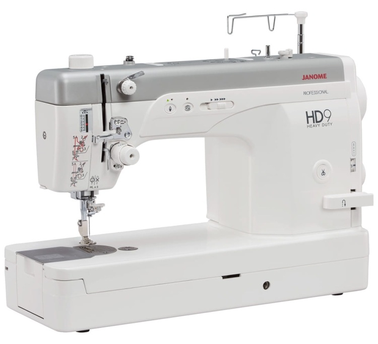Maszyna do szycia Janome HD9 Heavy Duty w kolorze białym z szarym panelem. Posiada widoczny mechanizm igły, przyciski sterujące oraz schowek na akcesoria. Ujęcie frontalne z widoczną płytką ściegową i logo HD9 HEAVY DUTY.