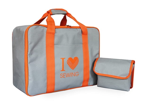 Torba Janome na maszynę do szycia, szara z pomarańczowymi uchwytami. Na froncie widoczny napis I ❤️ SEWING. Obok znajduje się mniejsza torba. Produkt leży na białym tle, z łatwym dostępem do uchwytów.