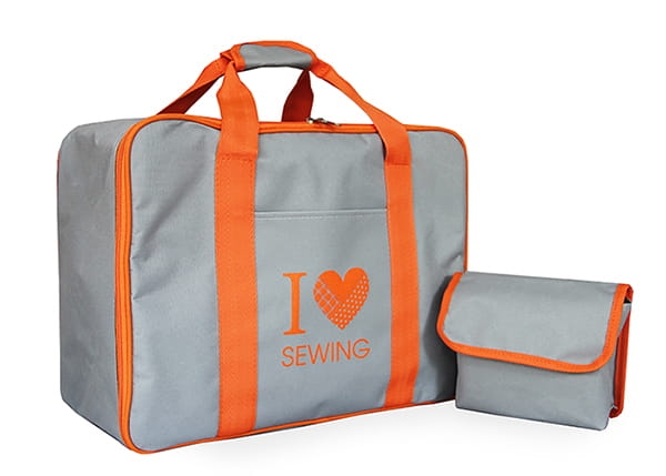 Torba Janome na maszynę do szycia, szara z pomarańczowymi uchwytami. Na froncie widoczny napis I ❤️ SEWING. Obok znajduje się mniejsza torba. Produkt leży na białym tle, z łatwym dostępem do uchwytów.