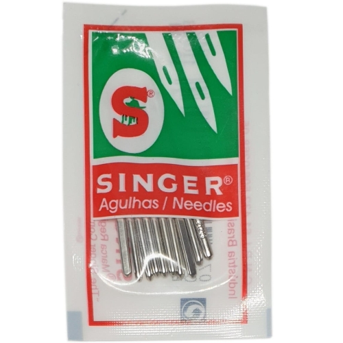 Igły półpłaskie ''90 Singer, opakowanie 10 sztuk. Metalowe igły z widocznym logo Singer oraz napisem Agulhas / Needles na białym tle. Opakowanie z kolorowymi detalami w zieleni i czerwieni, stojące, z igłami widocznymi na pierwszym planie.
