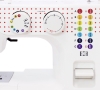 Maszyna do szycia Janome JUNO J15R w kolorze białym z czerwonymi kropkami. Posiada dwa pokrętła do ustawiania ściegów i długości, a także panel z symbolami różnych ściegów. Widoczny przycisk do szycia. Prosta konstrukcja, idealna dla początkujących.