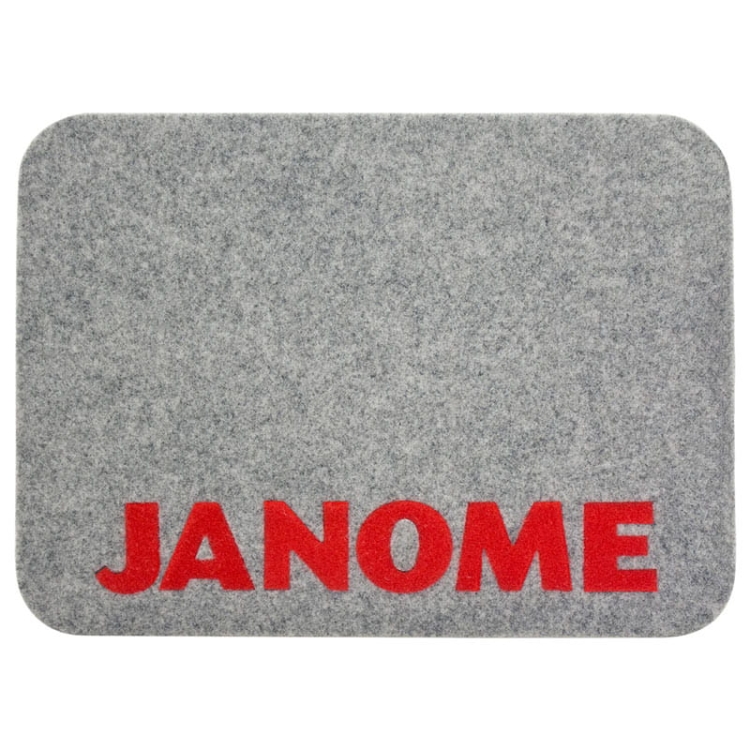 Podkładka filcowa Janome w kolorze szarym, o wymiarach 44 x 32 cm, z wyraźnym czerwonym napisem JANOME. Produkt leży na płasko, z zaokrąglonymi rogami, wykonany z miękkiego filcu, idealny pod maszyny do szycia.