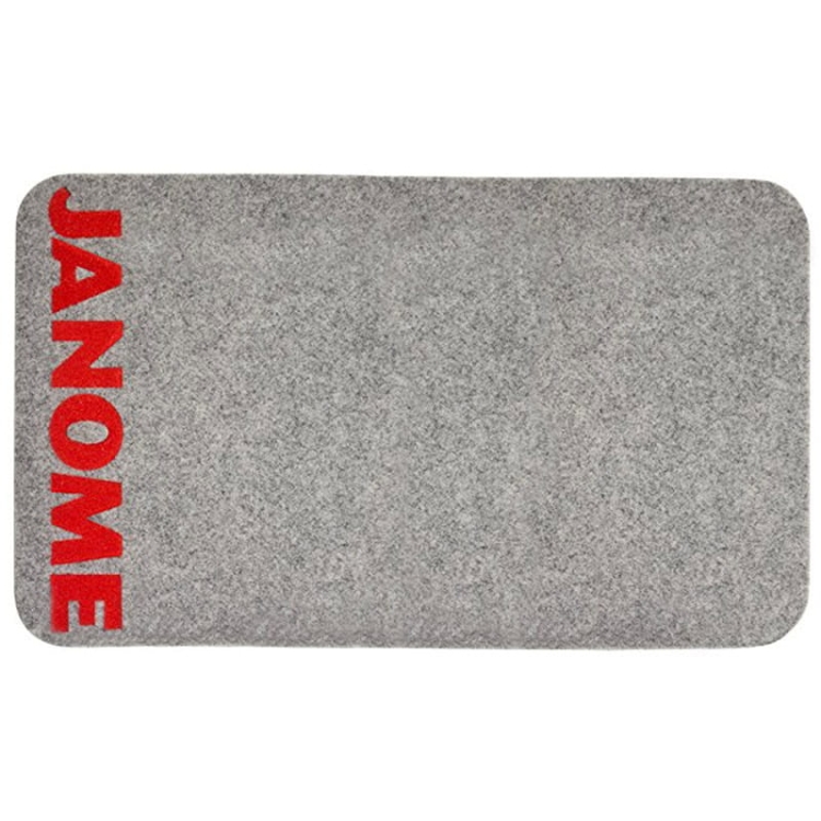 Szara podkładka filcowa Janome o wymiarach 61 x 37 cm, z logo JANOME w czerwonym kolorze. Produkt leży na płasko, z zaokrąglonymi rogami, idealny pod maszynę do szycia, zapewniający stabilność i ochronę powierzchni.