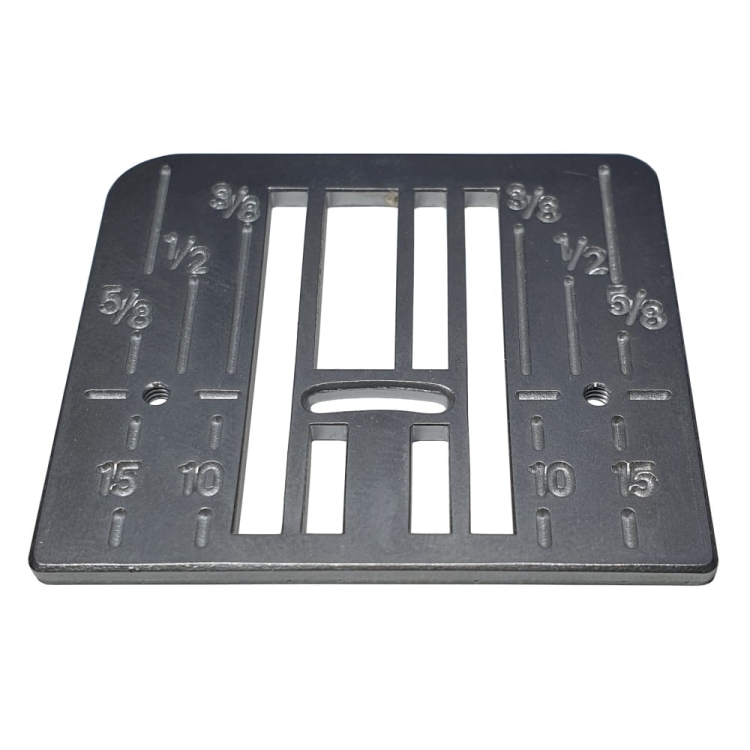 Część płytki ściegowej do maszyn Juno J30, J100, E1050 oraz Janome XL601 i DXL603. Płytka metalowa, prostokątna, z wycięciami i oznaczeniami długości (1, 5/8, 1/2, 3/8) oraz otworem montażowym na środku. Ujęcie z góry, na jednolitym tle.