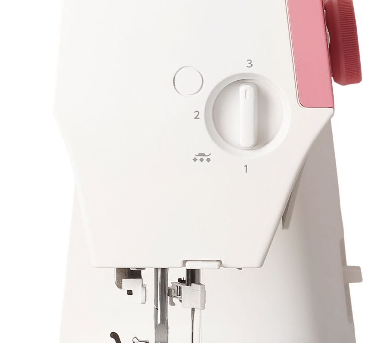 Maszyna do szycia Janome 1522 PG w kolorze różowym, z białą obudową. Widoczny mechanizm szycia z pokrętłem do regulacji oraz wskaźnikiem. Zbliżenie na igłę i stopkę, wskazówki dotyczące ustawienia. Prosty, funkcjonalny design.