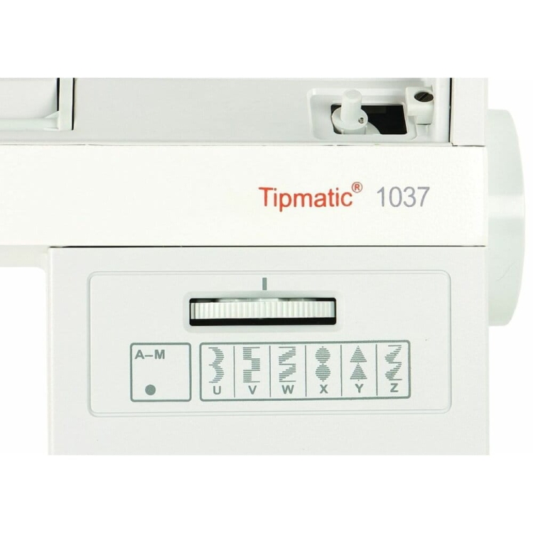 Maszyna do szycia Gritzner Tipmatic 1037 w białej obudowie, z logo Tipmatic i pokrętłem do wyboru ściegów. Widoczne różne wzory ściegów oznaczone literami A-M. Kąt ujęcia frontalny, pokazujący górną część maszyny.