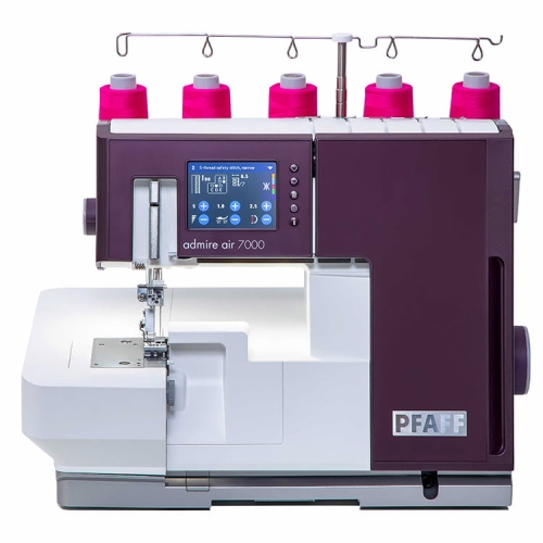 Coverlok PFAFF ADMIRE AIR 7000 z systemem łatwego nawlekania, w kolorze fioletowym z białymi elementami. Wyposażona w wyświetlacz LCD, z widocznymi szpulami oraz uchwytami. Stojąca, widok frontalny, ukazujący stół i igłę.