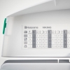 Panel maszyny do szycia Husqvarna Viking Jade 20 z wyświetlaczem funkcji i wzorów ściegów. Widoczne logo marki, tabela z oznaczeniami i parametrami ściegów, kolor biały, z elementami w szarości. Kąt ujęcia frontalny, pokazujący otwartą pokrywę.