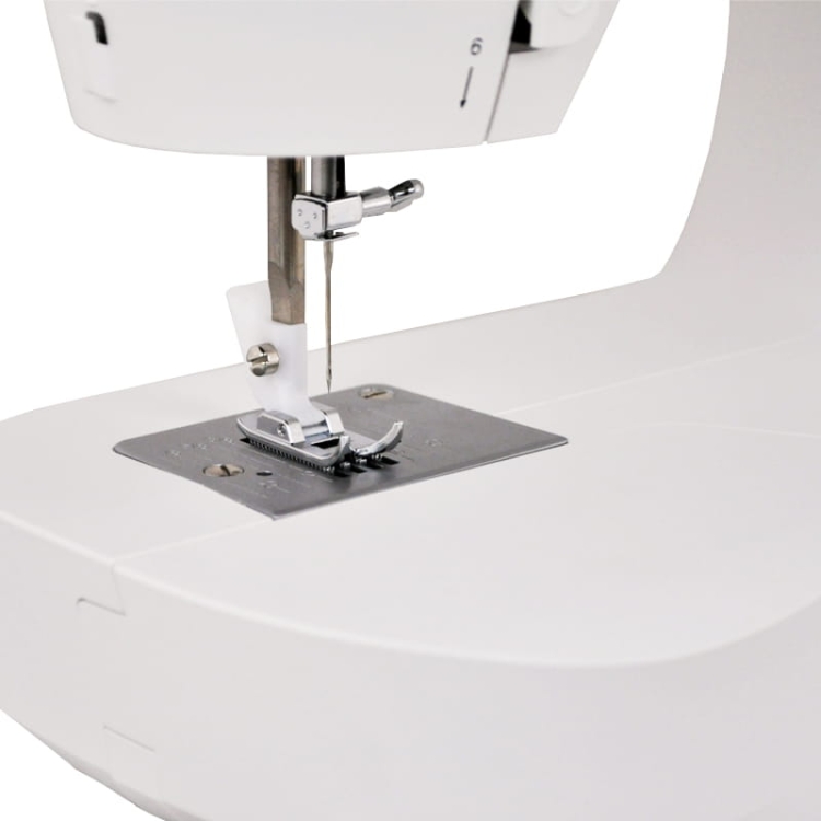 Maszyna do szycia Singer M1605, widok z bliska na igłę i stopkę na metalowej płycie. Użyte materiały w kolorze białym i srebrnym, z prostym, ergonomicznym designem. Idealna do szycia różnych tkanin.