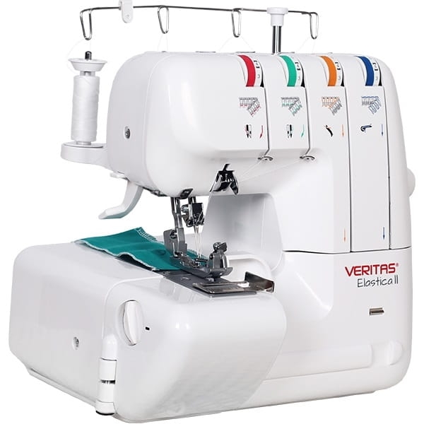 Owerlok Veritas Elastica II 4-nitkowy w kolorze białym, z widocznymi kolorowymi oznaczeniami nitkowania. Maszyna w pozycji stojącej, z zbliżeniem na stół roboczy i materiał w kolorze turkusowym. W zestawie szpulka z białą nicią.
