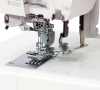 Renderka Janome CP3000P z metalową stopką i widoczną igłą, umieszczona na białej powierzchni. Ujęcie zbliżeniowe na mechanizm szycia, z wyraźnymi detalami, takimi jak prowadnik i zęby transportera. Idealna do szycia pokryć i wykończeń.