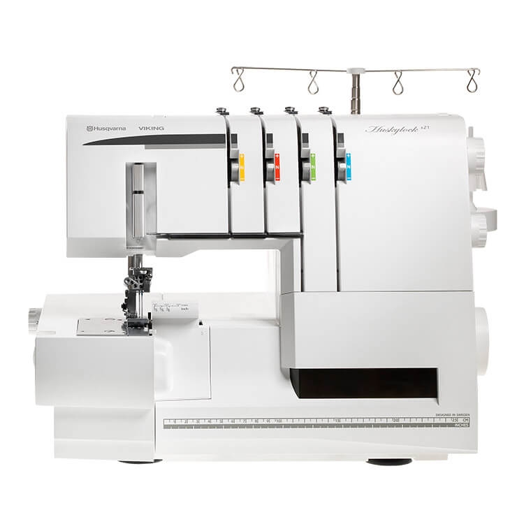 Overlock Husqvarna Viking HUSKYLOCK S21 w kolorze białym, z czterema wystającymi nitkami w kolorach żółtym, niebieskim, zielonym i pomarańczowym. Ujęcie frontalne, z widocznym uchwytem oraz elementami do szycia. Idealny do szycia z funkcją renderki.
