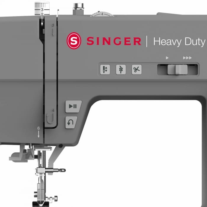 Maszyna do szycia Singer 6805C Heavy Duty w kolorze szarym, z wyraźnym logo SINGER. Widoczne przyciski funkcyjne i oznaczenia na obudowie. Ujęcie z boku, ukazujące igłę i stopkę. Idealna do szycia ciężkich materiałów.