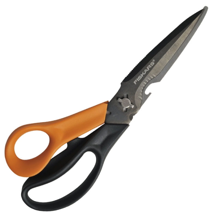 Nożyczki wielofunkcyjne Fiskars Cuts+More o długości 23 cm, z ostrzem w kolorze metalicznym, czarną i pomarańczową rączką. Posiadają ząbkowane krawędzie oraz dodatkowe funkcje, takie jak otwieracz do butelek. Ujęcie z boku, w pełnym rozłożeniu.