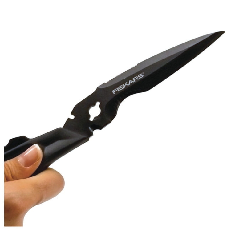 Nożyczki wielofunkcyjne Fiskars Cuts+More 23 cm, w kolorze czarnym, z ergonomicznym uchwytem. Ostrze ze ząbkowaną krawędzią i wycięciem, idealne do cięcia różnych materiałów. Ujęcie z boku, trzymane w dłoni.