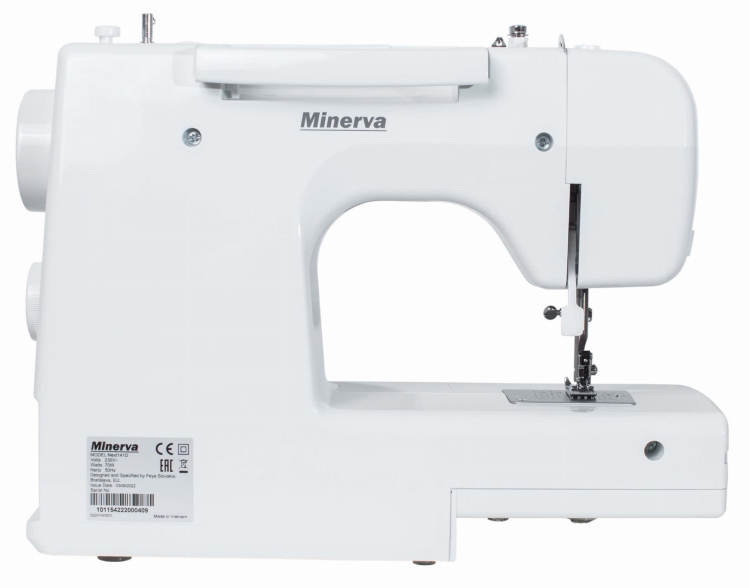Maszyna do szycia Minerva Next 141D II w kolorze białym. Widok z boku, pokazujący igłę, stopkę oraz pokrętła do regulacji. Na obudowie widoczne logo Minerva oraz etykieta z informacjami technicznymi. Prosty design, kompaktowy kształt.
