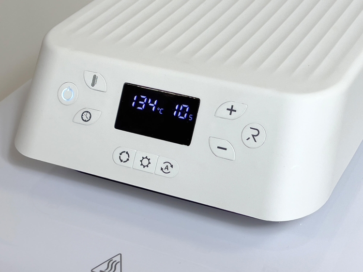 Panel sterujący prasy termotransferowej HTVRONT LOKLiK o wymiarach 38 x 38 cm. Widoczne przyciski do ustawiania temperatury i czasu, wyświetlacz LCD z temperaturą 134°C i czasem 10s. Kolor biały, matowa powierzchnia, z widocznymi ikonkami funkcji.