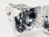 Owerlok Minerva ML3345 w przekroju, pokazujący mechanizm 4-nitkowy. Widoczne metalowe i plastikowe elementy, w tym sprężyny, śruby i prowadnice. Biała obudowa z otwartą pokrywą, ukazująca wnętrze maszyny.