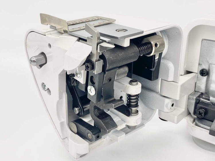 Owerlok Minerva ML3345 w przekroju, pokazujący mechanizm 4-nitkowy. Widoczne metalowe i plastikowe elementy, w tym sprężyny, śruby i prowadnice. Biała obudowa z otwartą pokrywą, ukazująca wnętrze maszyny.