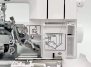 Owerlok Minerva ML3345 z widoczną konstrukcją 4-nitkową. Zbliżenie na mechanizm, z oznaczeniami kolorów do nawlekania nici. Obudowa w kolorze białym, z elementami metalowymi. Wyraźne instrukcje na panelu obok maszyny.