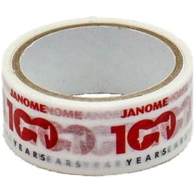 Taśma do szycia krawędziowego Janome 15 mm x 3 m w odcieniach bieli i czerwieni, z nadrukiem JANOME 100 YEARS oraz powtarzającym się wzorem. Produkt nawinięty na przezroczystą rolkę.