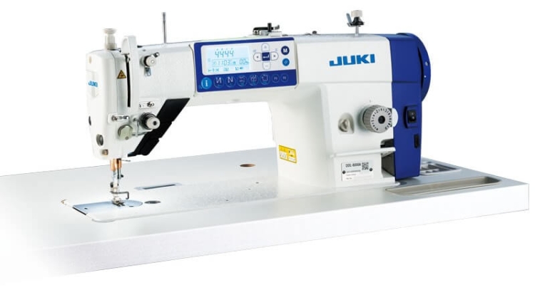 Stebnówka JUKI DDL-8000A-SH, 1-igłowa, automatyczna, przeznaczona do szycia średnich i ciężkich materiałów. Widok z boku, z wyświetlaczem LED, sterowaniem na obudowie i metalowym stelażem. Biały kolor maszyny na jasnym tle.