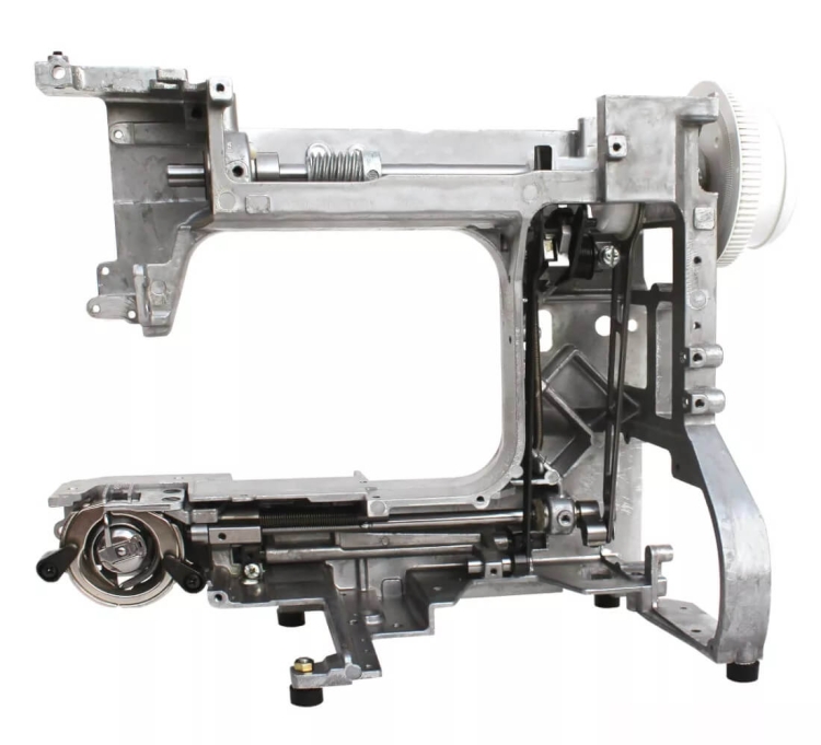 Maszyna do szycia Janome JUNO E1015 w kolorze zielonym, ukazująca metalową konstrukcję, z widocznymi elementami mechanicznymi, takimi jak bębenek i sprężyna. Ujęcie boczne, pokazujące detale wewnętrzne i mechanizmy.