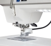 Maszyna do szycia Janome MC9480QCP Professional w zbliżeniu, pokazująca stopkę do szycia, igłę oraz panel sterujący. Biała obudowa, metalowe elementy, widoczny stół z oznaczeniami na powierzchni. Idealna do precyzyjnego szycia.