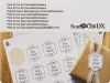 Kod aktywacyjny do funkcji cięcia po znacznikach Print to Cut (CADXPRNTCUT1) na tle arkuszy etykiet z napisem For You! w różnych wariantach, obok zapakowanego prezentu z wstążką. Widoczne napisy w kilku językach dotyczące obsługi funkcji.