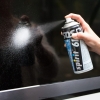 Pianka czyszcząca spray 400ml Spirit 61 w ręce, wydobywająca drobne cząstki pianki, skierowana na powierzchnię. Butelka w kolorze niebieskim i czarnym, z widoczną etykietą i napisem spirit 61. Tło ciemne, co podkreśla efekt czyszczenia.