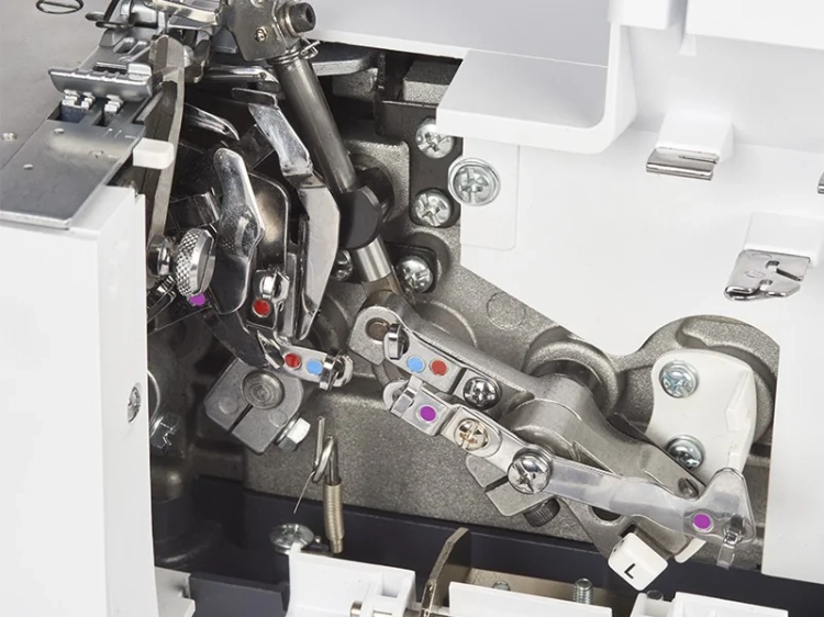 Zbliżenie na wnętrze owerloka BERNETTE B44 FUNLOCK, ukazujące mechanizm z metalowymi elementami, dźwigniami i kolorowymi oznaczeniami. Widoczne śruby oraz części robocze maszyny, z jasnym tłem, co podkreśla detale konstrukcyjne.