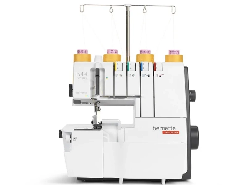 Owerlok BERNETTE B44 FUNLOCK 4-nitkowy w kolorze białym z elementami szarymi, z pięcioma szpulkami nici. Widoczny mechanizm szyjący z napisem bernette oraz logo SWISS DESIGN. Ujęcie z boku, stojący, detal na maszynie do szycia.