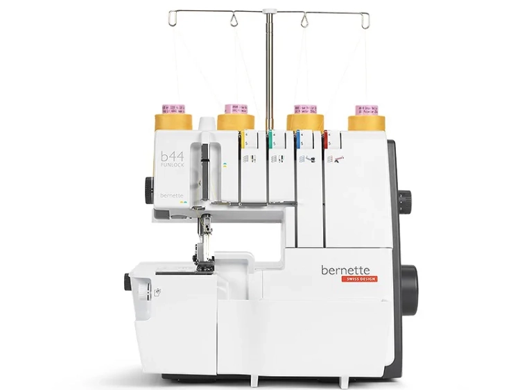 Owerlok BERNETTE B44 FUNLOCK 4-nitkowy w kolorze białym z elementami szarymi, z pięcioma szpulkami nici. Widoczny mechanizm szyjący z napisem bernette oraz logo SWISS DESIGN. Ujęcie z boku, stojący, detal na maszynie do szycia.