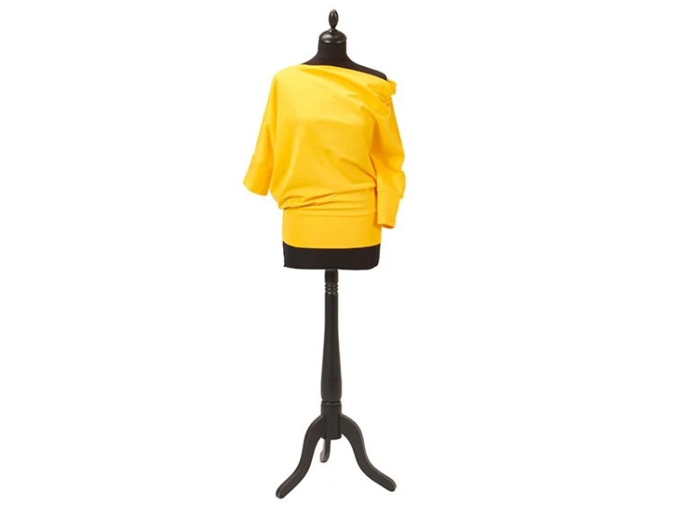 Oversize bluza w intensywnym, słonecznym żółtym kolorze, z asymetrycznym dekoltem i długimi rękawami. Prezentowana na manekinie, z wyraźnym ściągaczem na dole. Tło jasne, co podkreśla kolor materiału.