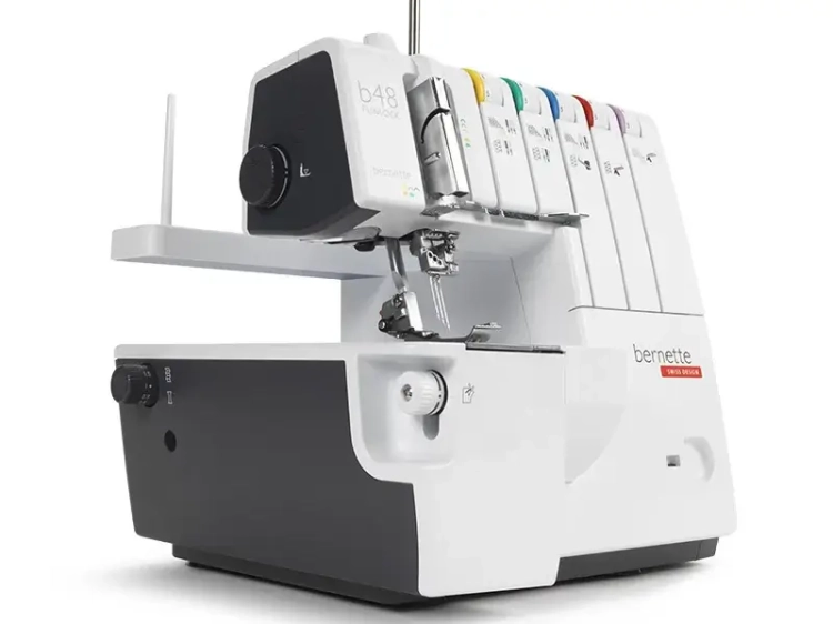 Overlock BERNETTE B48 FUNLOCK w kolorze białym i czarnym, z funkcją renderki. Widok z boku, z widocznymi sześcioma szpulami w różnych kolorach oraz dużym pokrętłem do ustawiania. Wbudowane elementy do szycia, w tym igła i stopka.