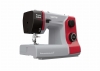 Maszyna do szycia Veritas Power Stitch PRO w kolorze szaro-czerwonym, z mechanicznymi pokrętłami do regulacji ściegów i długości. Widoczny stół z podziałką oraz igła w dolnej części. Kąt ujęcia z boku, pokazujący detal i konstrukcję maszyny.