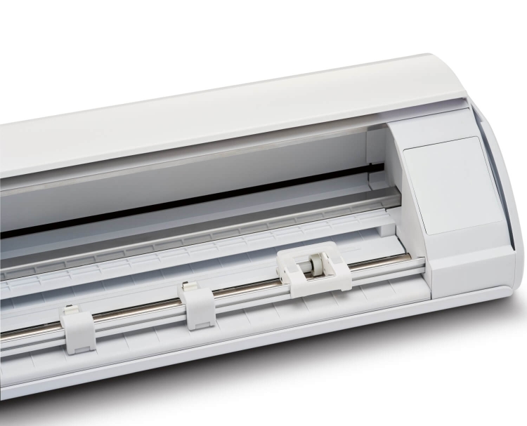 Ploter tnący Silhouette Cameo 5 w kolorze białym, widok z góry, z otwartą pokrywą. Wnętrze urządzenia z metalowym wałkiem i białymi uchwytami, gotowe do cięcia materiałów. Prosta, nowoczesna konstrukcja.