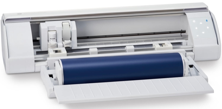 Ploter tnący Silhouette Cameo 5 w kolorze białym, z otwartą szufladą, w której widoczna jest niebieska rolka materiału. Urządzenie ma prostokątny kształt, z przyciskami i wskaźnikami LED na boku. Wnętrze pokazuje elementy mechaniczne i prowadnice.
