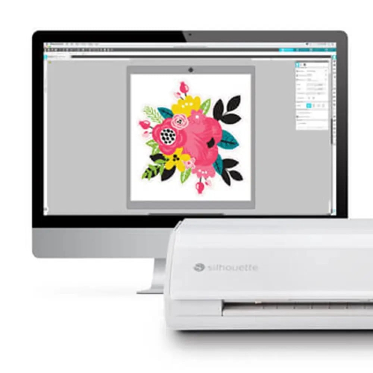 Ploter tnący Silhouette Cameo 5 Plus w kolorze białym, z umieszczonym na biurku, z widoczną grafiką kwiatową na ekranie komputera. Urządzenie ma prosty, nowoczesny kształt z logo Silhouette. Ujęcie frontalne, eksponujące detal pracy.