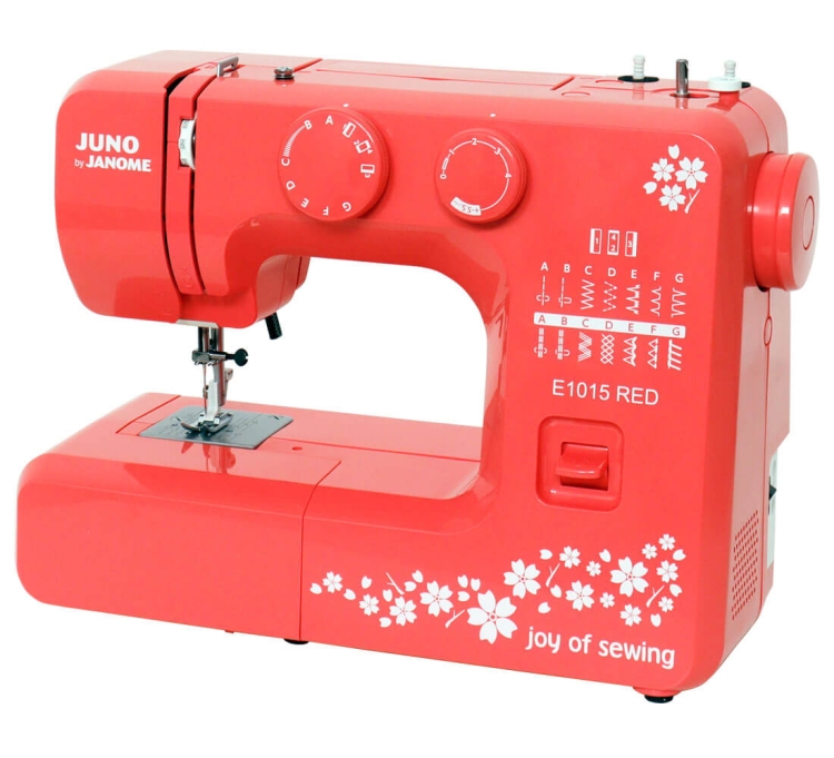 Maszyna do szycia Janome JUNO E1015 w kolorze czerwonym, z białymi kwiatowymi detalami. Widoczne pokrętła do regulacji oraz panel z różnymi wzorami ściegów. Ujęcie frontalne, produkt stojący na płaskiej powierzchni.