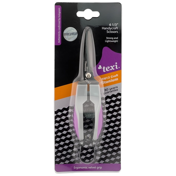 Nożyczki tapicerskie TEXI Titanium Ti613 o długości 16 cm z ergonomiczną, welurową rączką. Cienkie ostrza w kolorze srebrnym, zapakowane na tle czarno-białym z logo texi oraz informacjami o gwarancji.