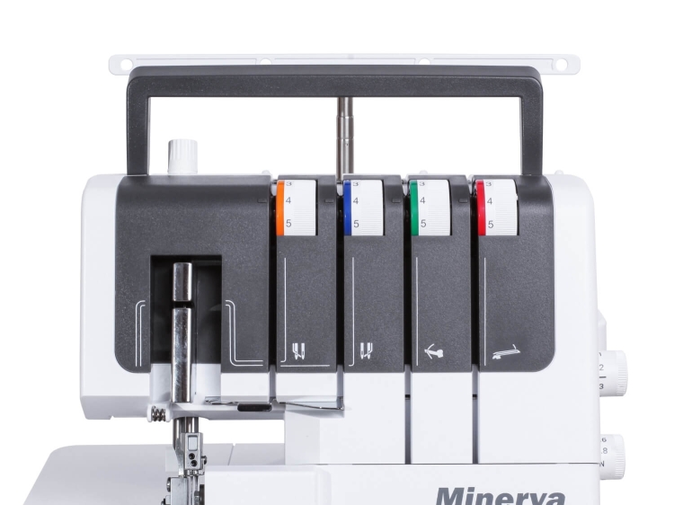 Owerlok Minerva M1040DS 4-nitkowy, frontalny widok, z czarną i białą obudową. Na górze widoczne pokrętła w kolorach niebieskim, zielonym, czerwonym i pomarańczowym. Elementy maszyny do szycia, w tym igły i prowadnice, są dobrze widoczne.