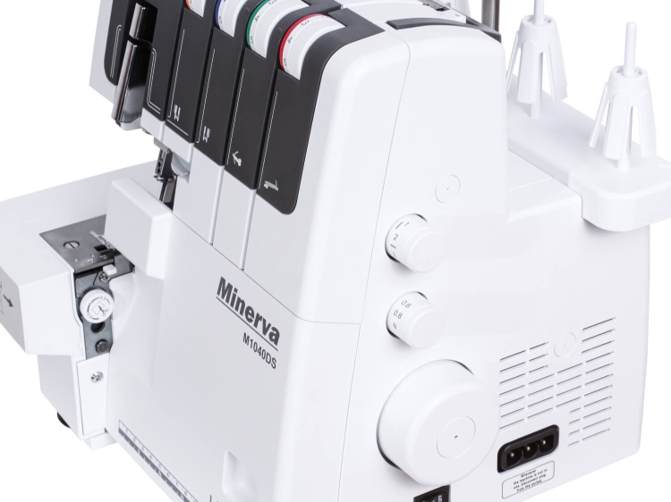 Owerlok Minerva M1040DS 4-nitkowy w kolorze białym, z widocznymi pokrętłami do regulacji napięcia nici. Na zdjęciu widać także gniazdo elektryczne oraz miejsce na szpule. Maszyna umieszczona na płaskiej powierzchni, z widokiem z boku.