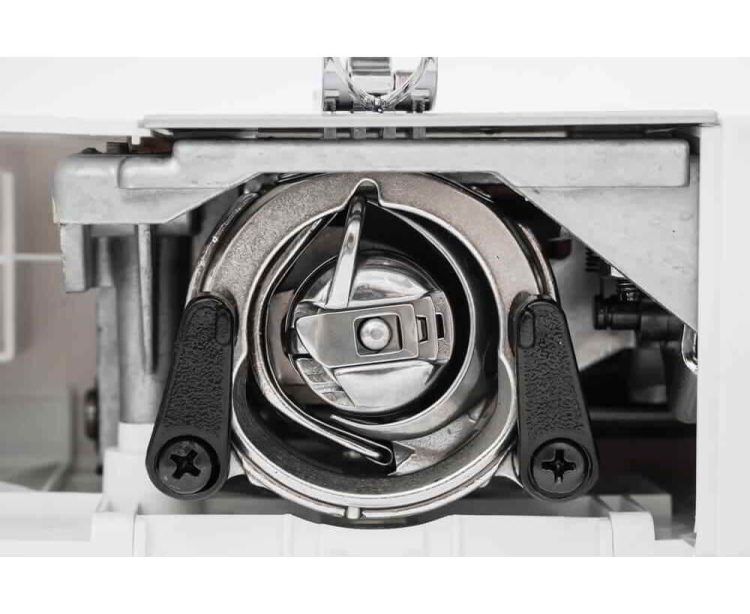 Zbliżenie na mechanizm bębenka maszyny do szycia Minerva La Vento 750LV. Widoczny metalowy bębenek z czarnymi uchwytami, w środku elementy mechaniczne. Tło jasne, podkreślające detale konstrukcji.