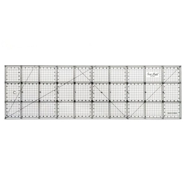 Linijka do patchworku i quiltingu o wymiarach 150x500 mm, wykonana z przezroczystego tworzywa. Posiada siatkę z oznaczeniami milimetrowymi, kąty oraz przekątne, co ułatwia precyzyjne cięcie materiałów. Ujęcie frontalne, na białym tle.