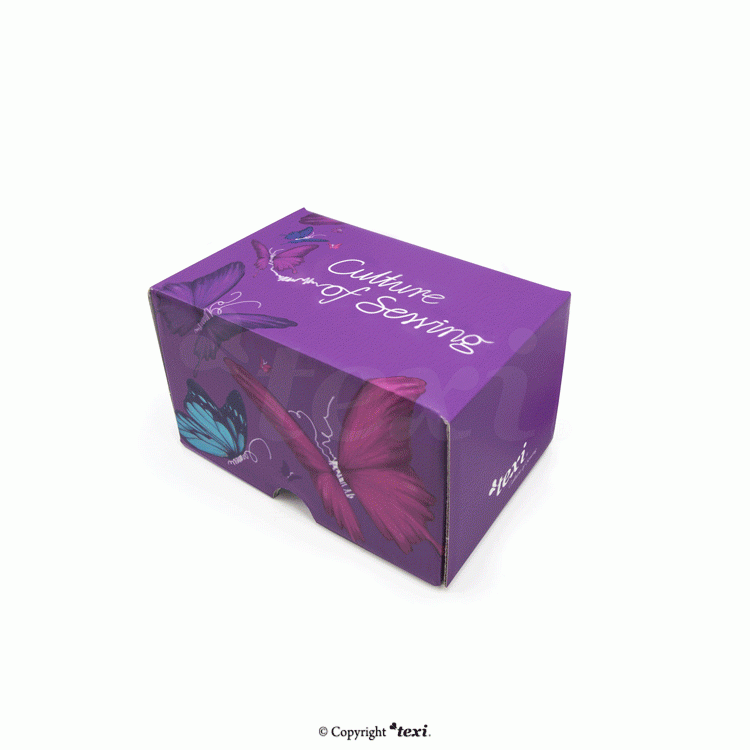 Zestaw 15 nici Ariadna w kolorowym pudełku BOX z grafiką motyli. Pudełko ma fioletowy kolor z napisem Culture of Sewing. Widoczne są detale graficzne oraz logo TEXI na boku opakowania.